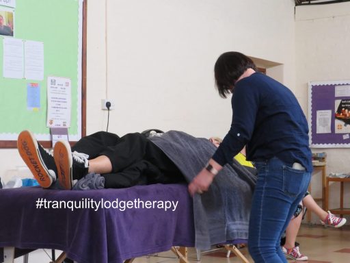 Towels being rolled to swaddle client on couch