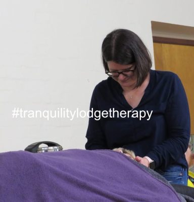 Restorative touch - therapist holding head of client lying on couch