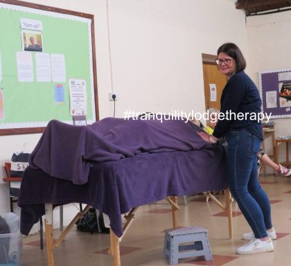 Restorative Touch - therapist holding the arms/wrist of client lying on couch
